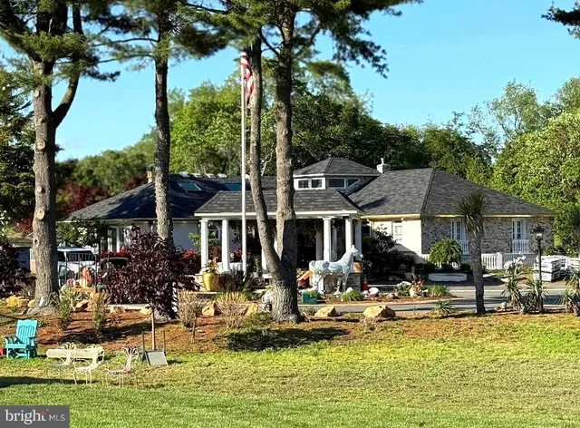 a front view of a house with swimming pool lawn chairs and a fountain