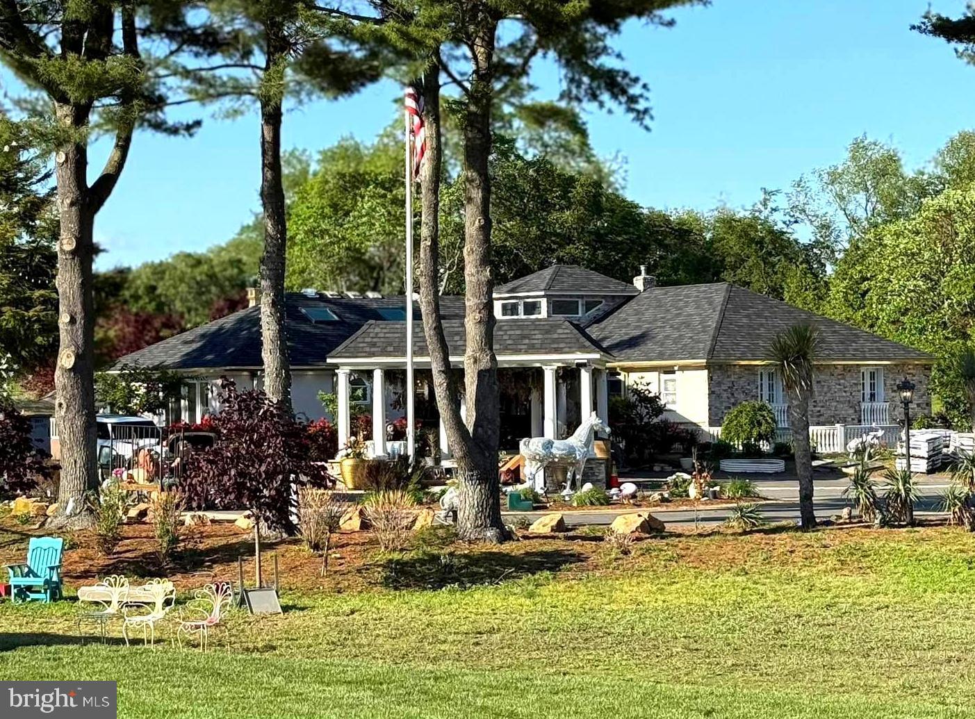 a front view of a house with swimming pool lawn chairs and a fountain