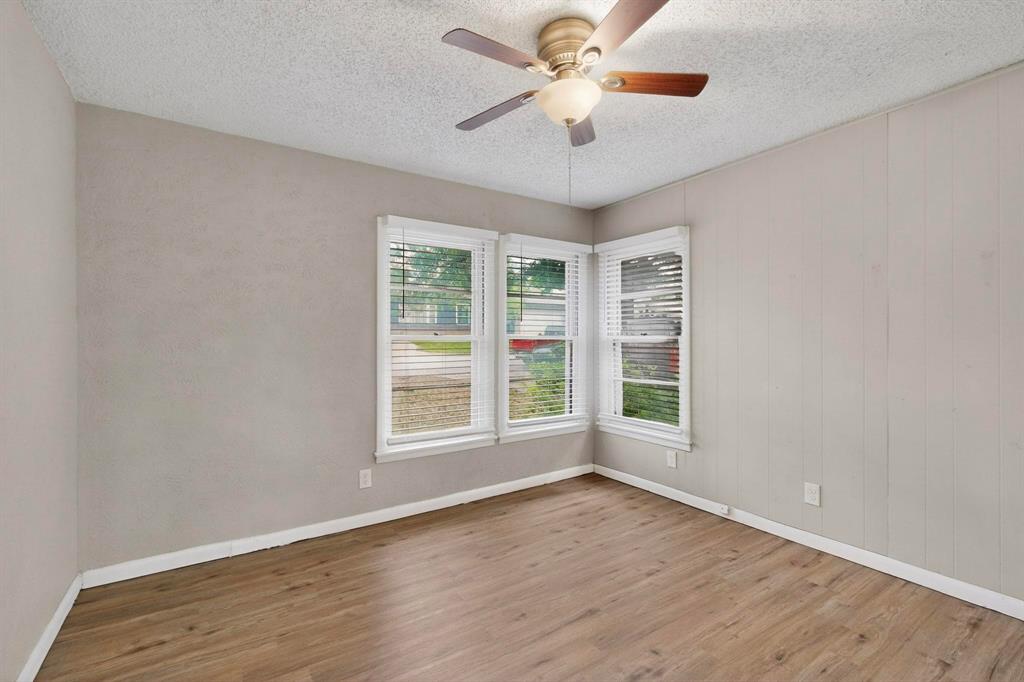 4508 Rutland Avenue Fort Worth, TX 76133 - Photo 25 of 36 an empty room with wooden floor chandelier fan and windows