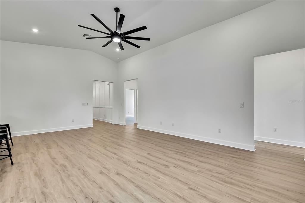 6589 Freeport Drive Spring Hill, FL 34608 - Photo 13 of 63 a view of an empty room with wooden floor and a ceiling fan