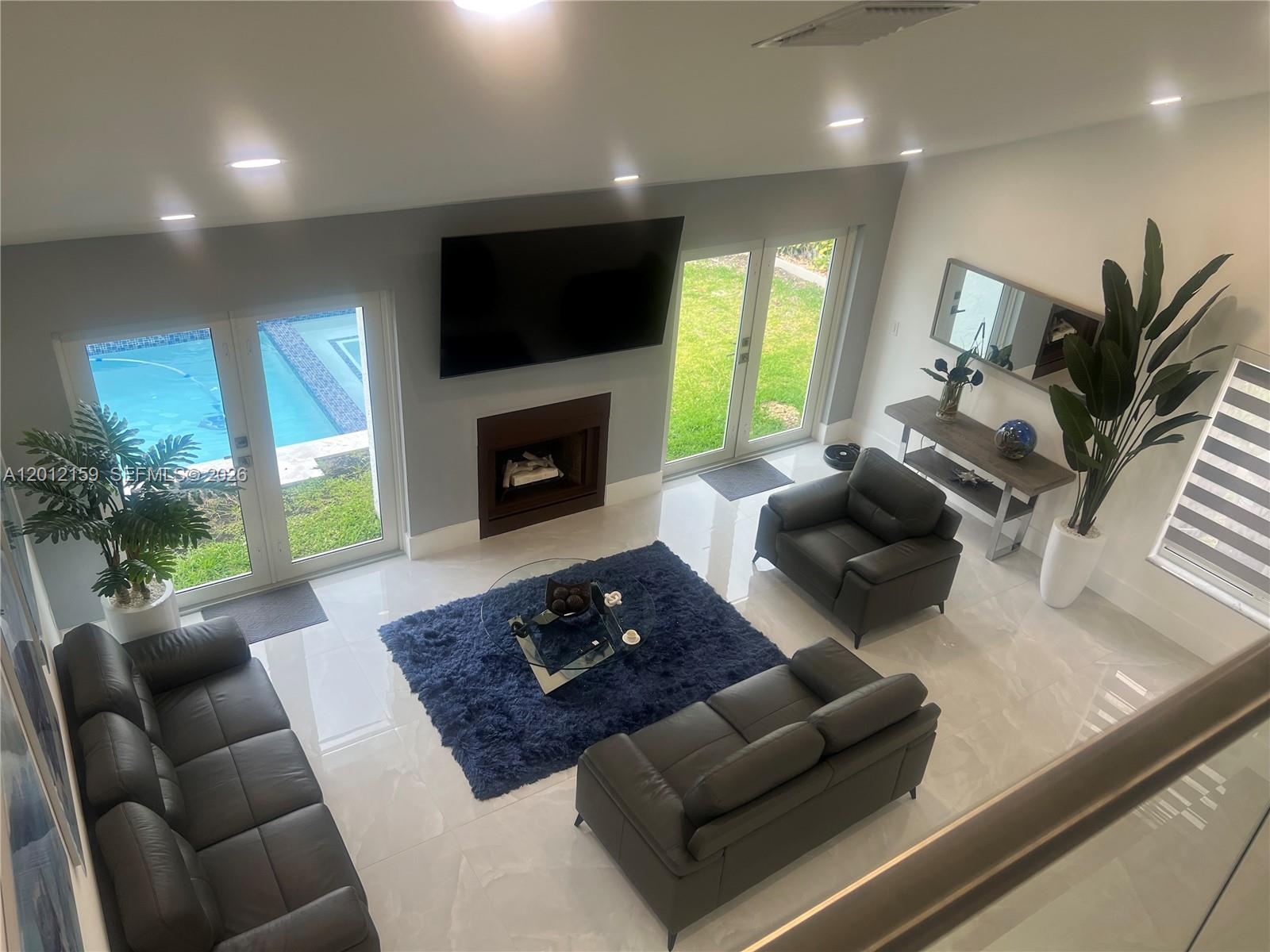13595 Southwest 99th Street Miami, FL 33186 - Photo 41 of 44 a living room with furniture flat screen tv and a fireplace