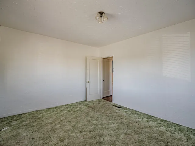 an empty room with wooden floor and door