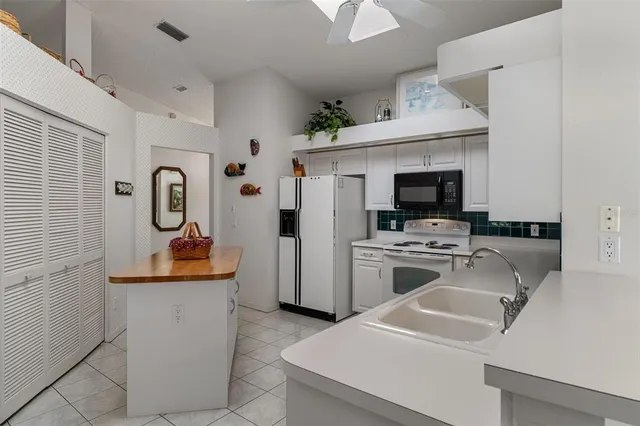 a kitchen with refrigerator and stove top oven