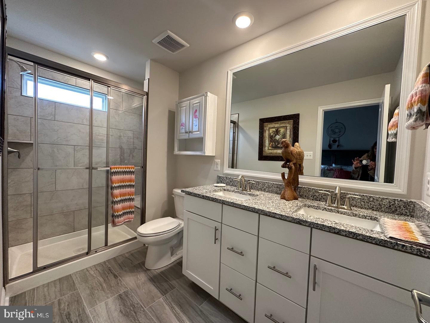 35393 Wright Way Millsboro, DE 19966 - Photo 13 of 28 a bathroom with a granite countertop sink a toilet a mirror and shower