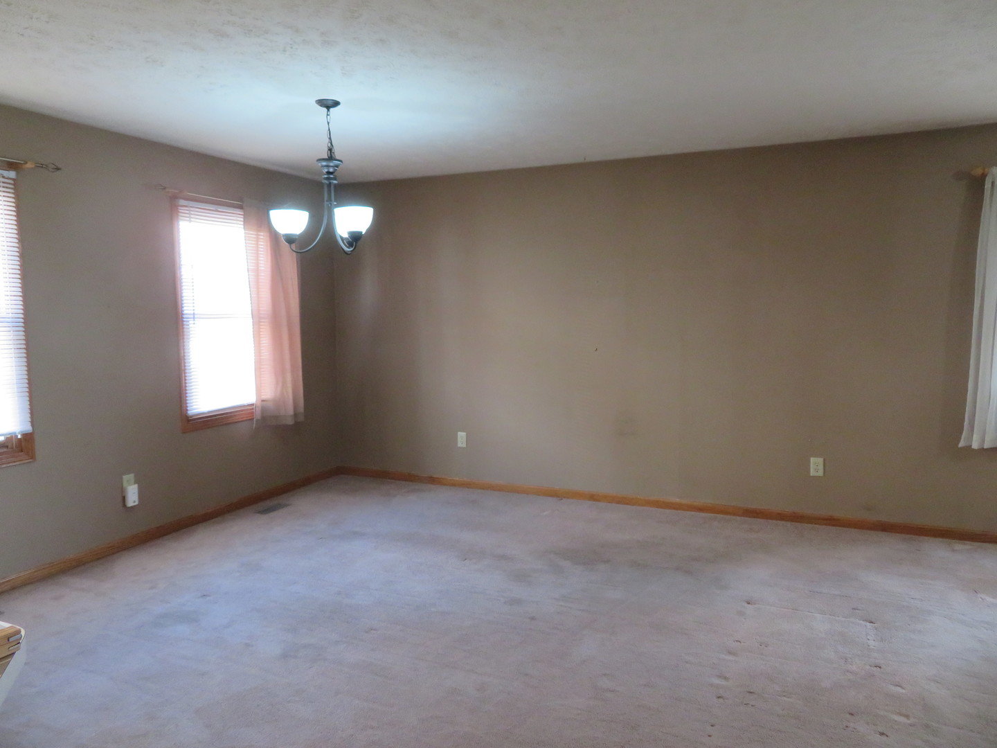 440 South Peace Road, Unit 440 Sycamore, IL 60178 - Photo 4 of 19 an empty room with a window and chandelier fan