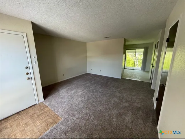 a view of an empty room with a fireplace and a window