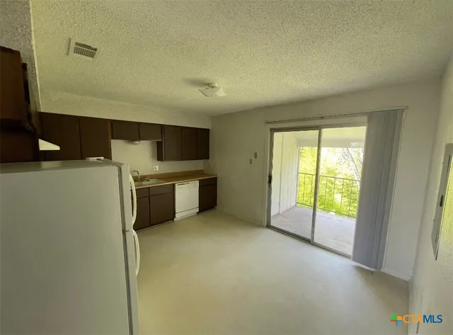 a view of a kitchen with a sink an oven and refrigerator