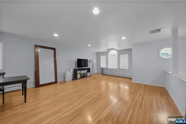 a view of empty room with wooden floor and window