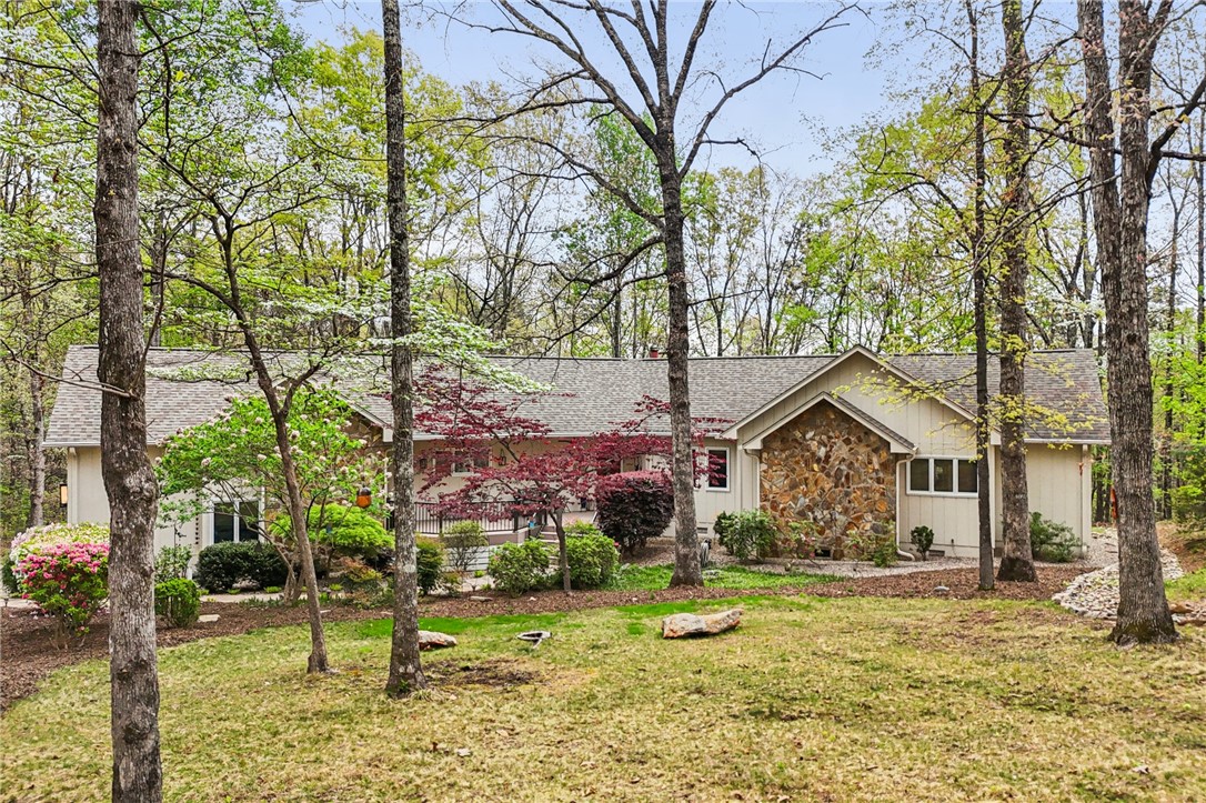 120 Beacon Ridge Circle Salem, SC 29676 - Photo 2 of 49 This charming home features a stone and wood facade, set amidst a vibrant, wooded landscape.