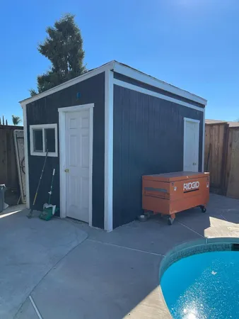 a backyard of a house with barbeque oven table and chairs