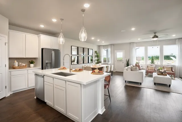 a kitchen that has a lot of white cabinets counter space and stainless steel appliances