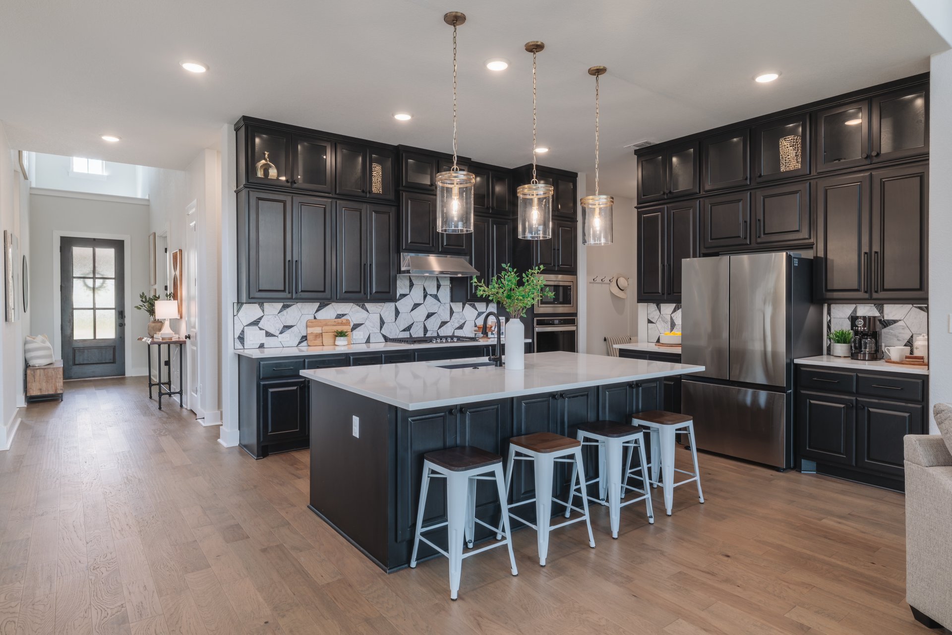317 Autumn Oak Way Georgetown, TX 78628 - Photo 9 of 40 a kitchen with stainless steel appliances granite countertop a refrigerator a stove top oven and a center island with wooden floor