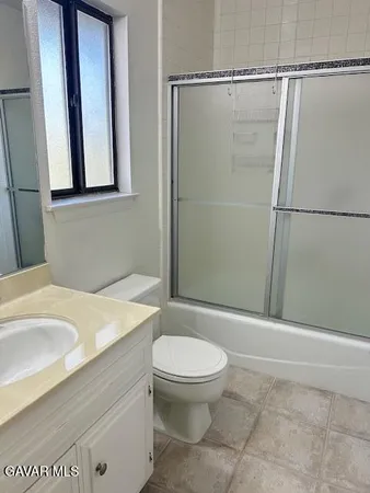 a bathroom with a granite countertop sink a toilet and a mirror