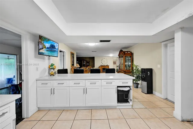 a kitchen with white cabinets and appliances