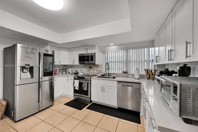 a kitchen with stainless steel appliances and white cabinets
