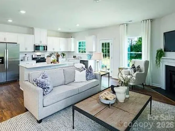 a living room with furniture kitchen view and large windows