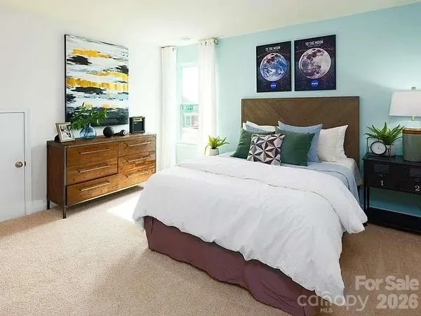 a bed room with a bed and a painting on the wall