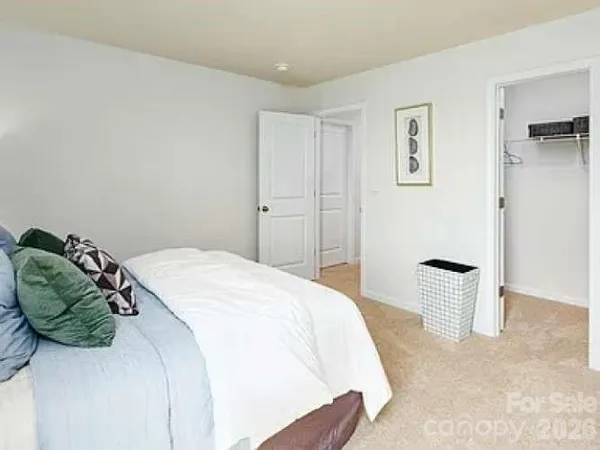 a bedroom with a bed and painting on the wall