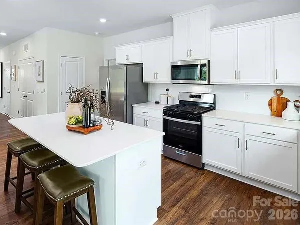 a kitchen with a sink a stove and chairs