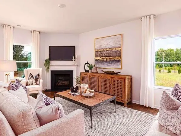 a living room with furniture a flat screen tv and a fireplace