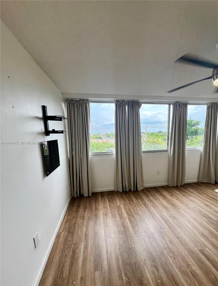 1750 West 56th Street, Unit 211 Hialeah, FL 33012 - Photo 11 of 19 an empty room with wooden floor and windows