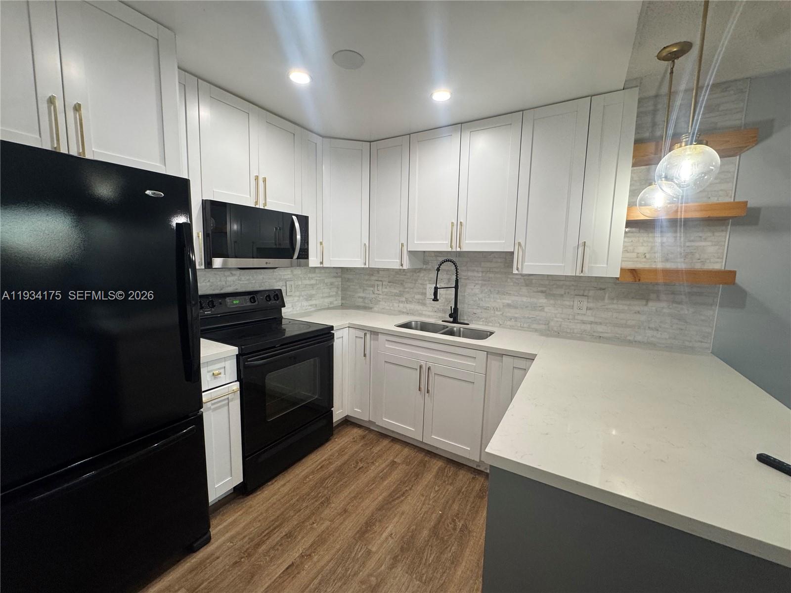 1750 West 56th Street, Unit 211 Hialeah, FL 33012 - Photo 13 of 19 a kitchen with a sink stainless steel appliances and cabinets