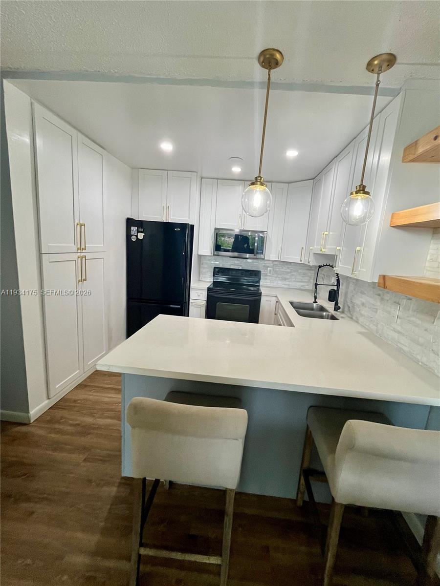 1750 West 56th Street, Unit 211 Hialeah, FL 33012 - Photo 2 of 19 a kitchen with kitchen island a table and chairs in it