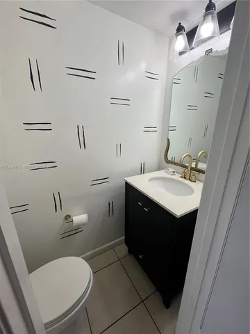 a bathroom with a sink vanity mirror and toilet