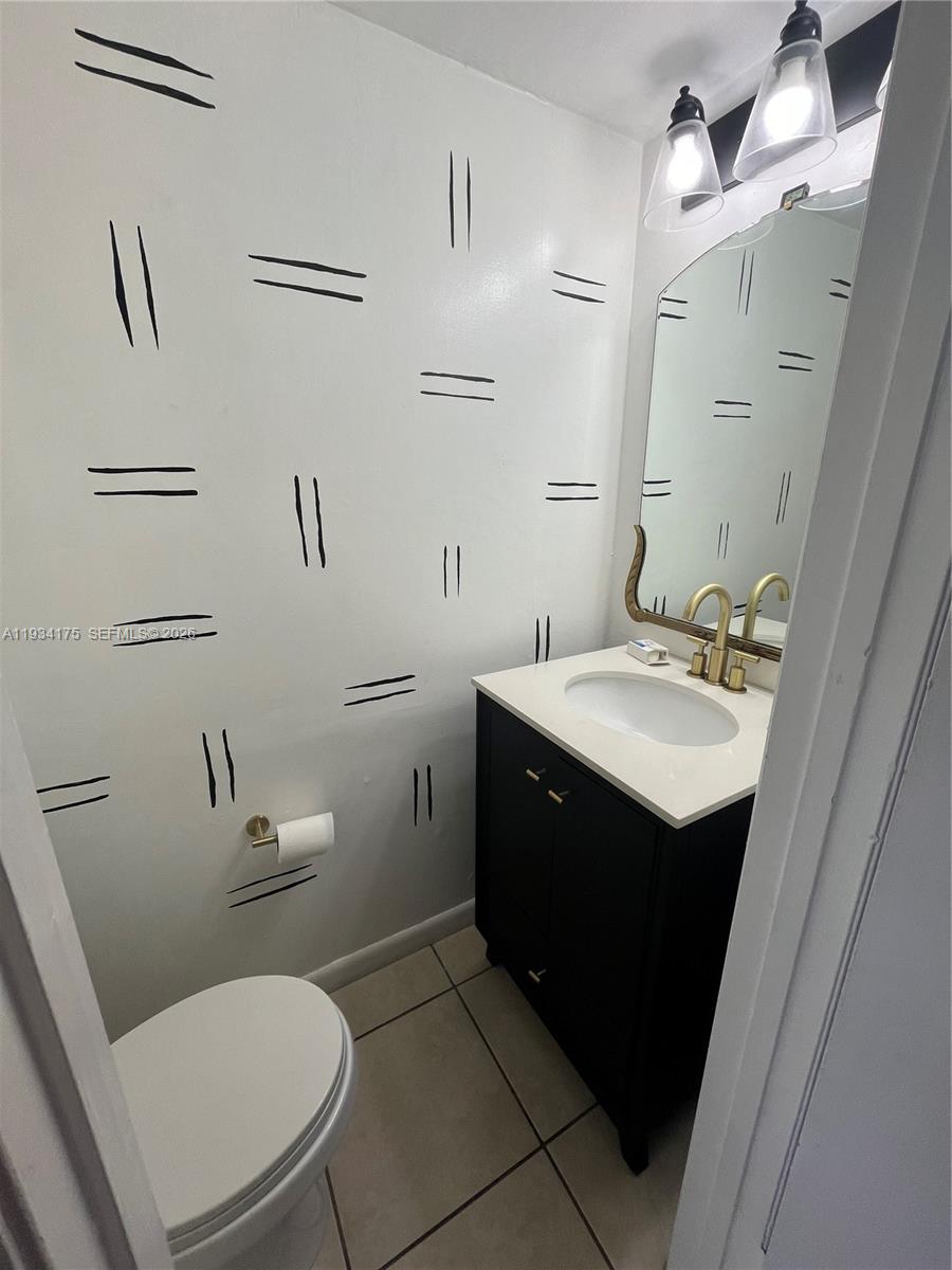 1750 West 56th Street, Unit 211 Hialeah, FL 33012 - Photo 6 of 19 a bathroom with a sink vanity mirror and toilet
