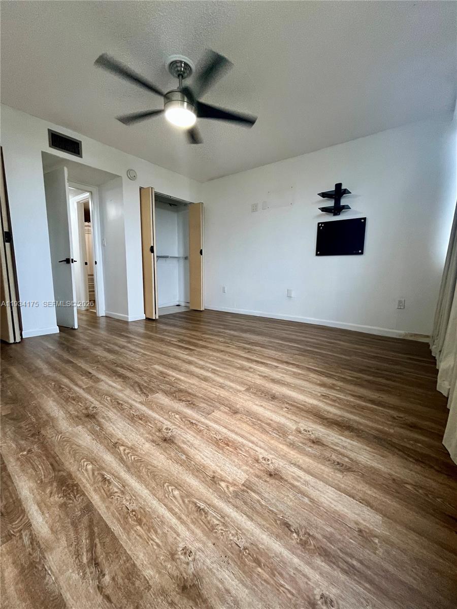 1750 West 56th Street, Unit 211 Hialeah, FL 33012 - Photo 8 of 19 a view of a livingroom with a ceiling fan and wooden floor