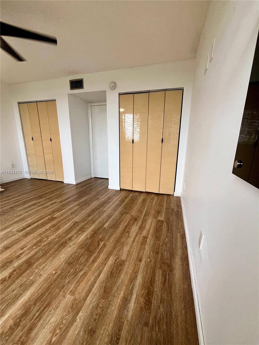 1750 West 56th Street, Unit 211 Hialeah, FL 33012 - Photo 10 of 19 a view of a room with wooden floor and a ceiling fan
