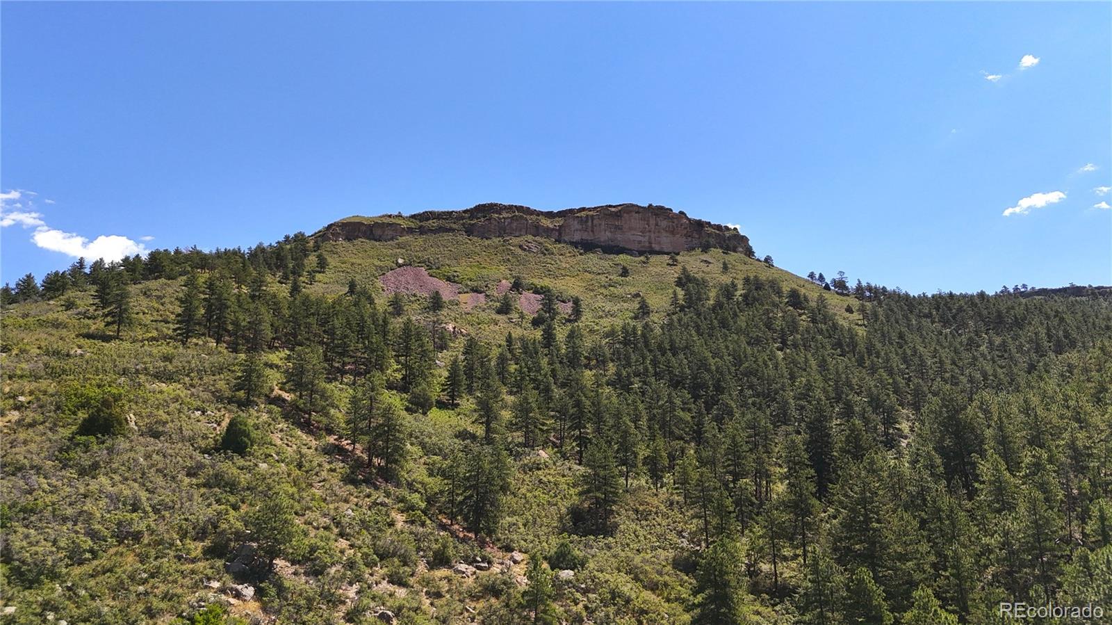 5080 South Perry Park Road Sedalia, CO 80135 - Photo 31 of 39 a view of a large building with a mountain in the background
