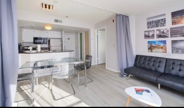 a living room with furniture and a kitchen view