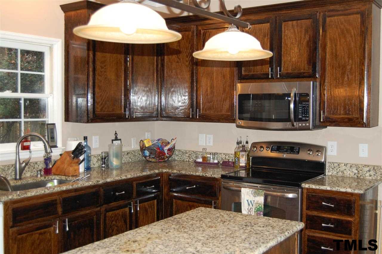 9505 Meadowmont Lane Raleigh, NC 27615 - Photo 15 of 18 a kitchen with stainless steel appliances wooden cabinets a stove a sink and a microwave