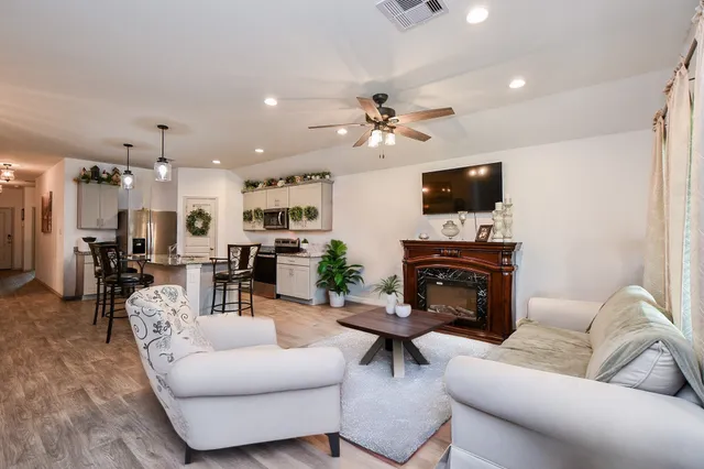 a living room with furniture a fireplace and a flat screen tv