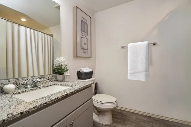 a bathroom with a granite countertop sink and a mirror