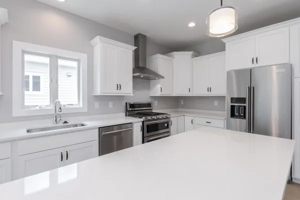 a kitchen with white cabinets and refrigerator
