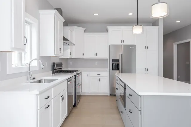 a kitchen with cabinets appliances a sink and a window