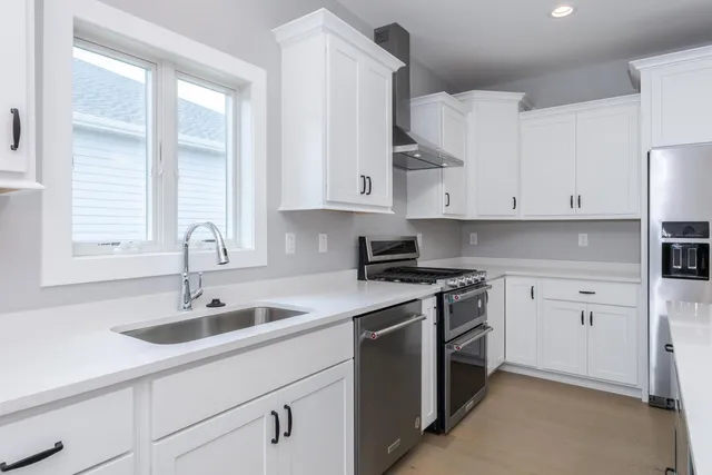 a kitchen with lot of cabinets and wooden floor