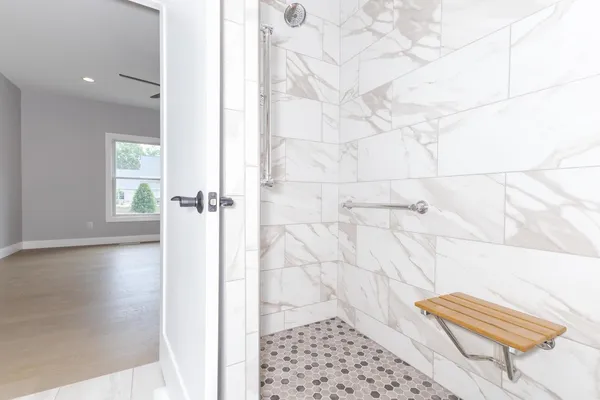 a spacious bathroom with a double vanity sink a large mirror and a shower