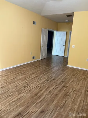 an empty room with wooden floor and entryway