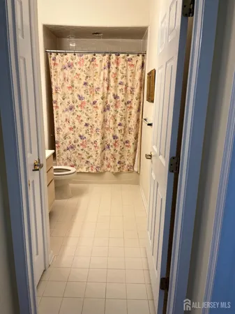 a view of a hallway with wooden floor and a dining room