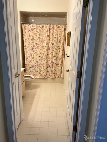 a view of a hallway with wooden floor and a dining room