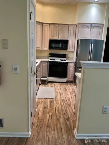 a kitchen with stainless steel appliances granite countertop a refrigerator sink and white cabinets