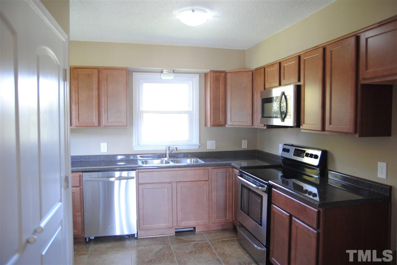 1821 Billingham Court Raleigh, NC 27604 - Photo 6 of 14 a kitchen with stainless steel appliances granite countertop a stove a sink and a microwave