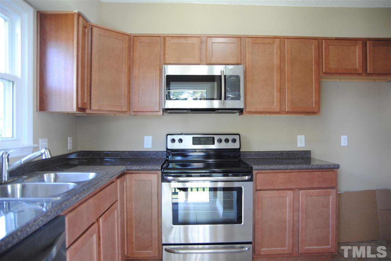 1821 Billingham Court Raleigh, NC 27604 - Photo 7 of 14 a kitchen with granite countertop a stove and a sink