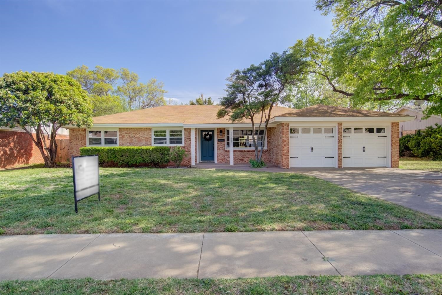 2311 61st Street Lubbock, TX 79412 - Photo 2 of 32 a front view of a house with a garden and yard