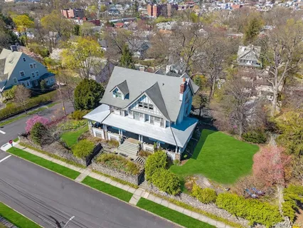a view of a big house with a big yard and potted plants