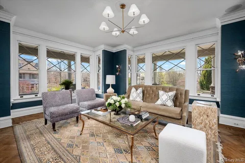 a view of a dining room with furniture a chandelier and wooden floor