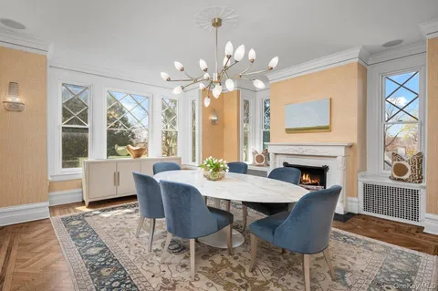a living room with furniture a fireplace and a chandelier